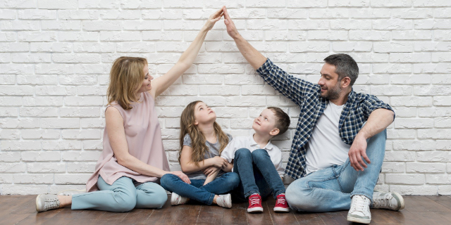 Eltern bilden symbolisch ein Dach über den Kopf der Kinder.