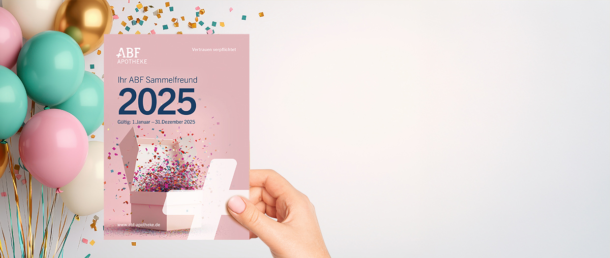 Eine Hand hält den Sammelfreund 2025 vor einem Hintergrund aus Luftballons