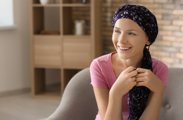 Frau mit Kopftuch sitzt auf einem Sessel und lacht